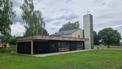 Moderní veřejná budova s dřevěným obvodem a skleněnými okny.