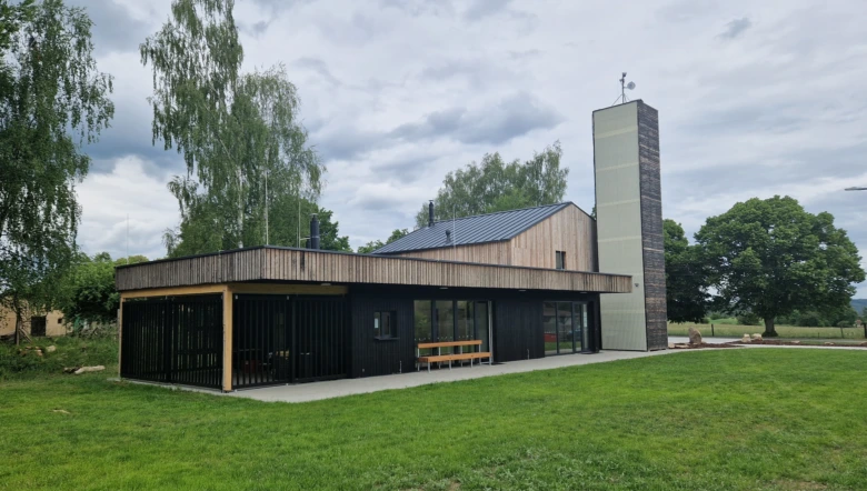 Moderní veřejná budova s dřevěným obvodem a skleněnými okny.