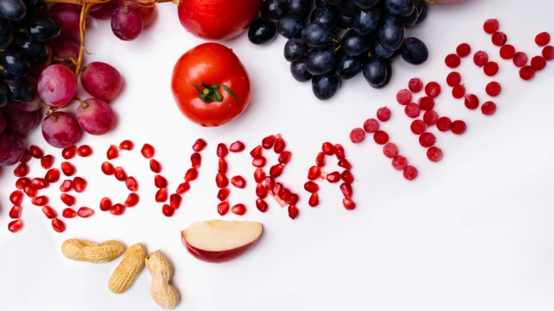 Červené granáty tvořící slovo resveratrol s víno hroznů jablky oříšky