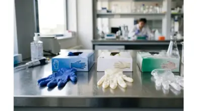 Modré bílé a průhledné nitrilové rukavice na laboratorním stole.
