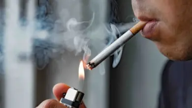 Muž zapaluje cigaretu zapaľovačem s výfukem kouře.