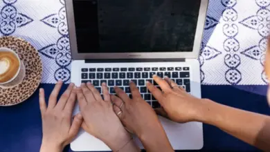 Hands typing on laptop