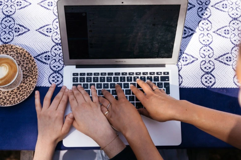Hands typing on laptop