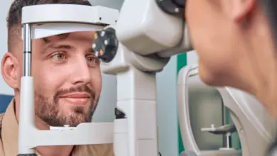 Muž se dívá do optometrického přístroje při vyšetření zraku.
