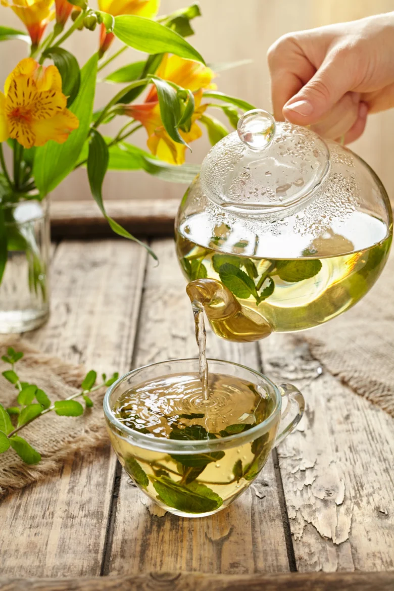 Pouring herbal tea with mint leaves