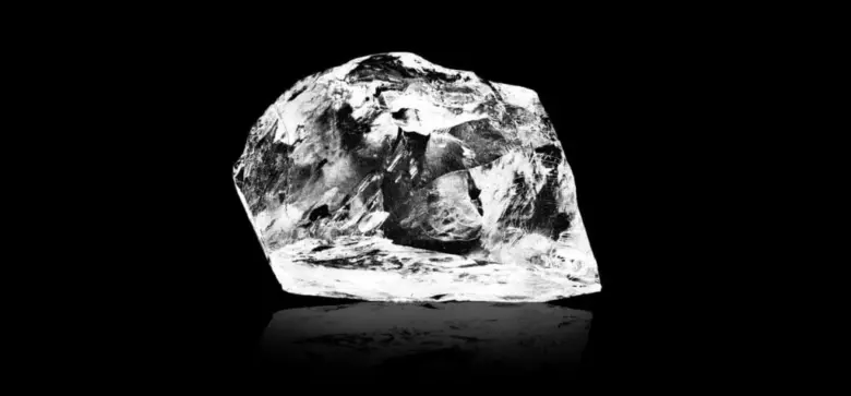 Neupravený hrubý diamant na černém pozadí.