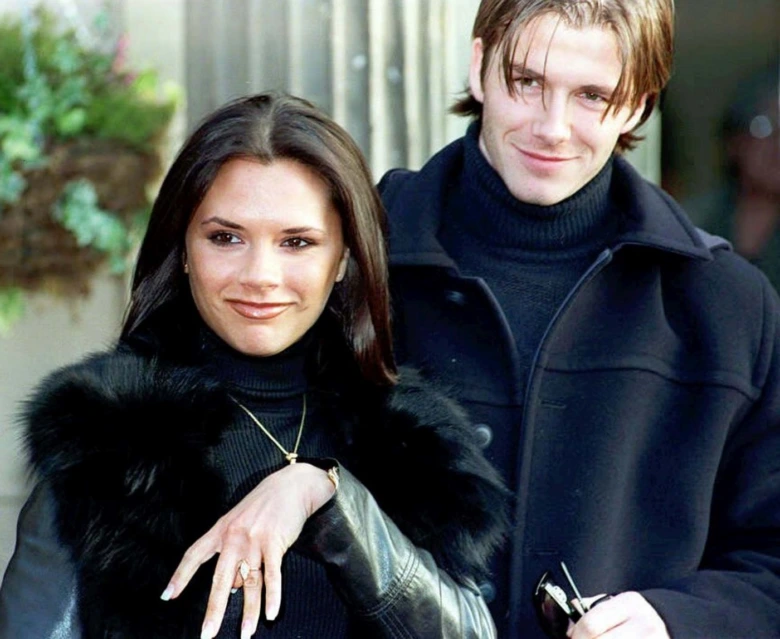 David a Victoria Beckham stojí vedle sebe venku.