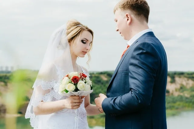 Nejmenší svatební pár v bílém šatu s květinami.