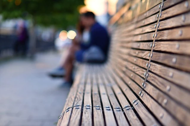 Wooden bench with blurred couple
