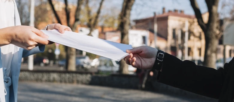 Ruční předání dokumentu venku na slunci