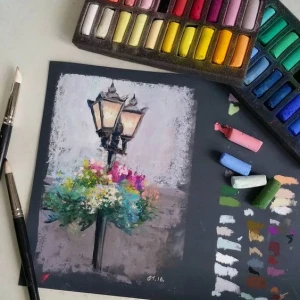 Kresba vodou s barevnými pastely a štětcemi na umění.