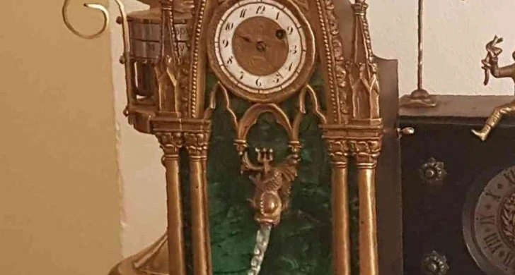 Zlaté starožitné hodiny s kmitavým závažím.