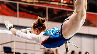 Žena gymnastka na lavičkách v soutěži.