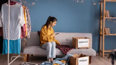 Žena třídí oblečení do krabic pro darování nebo prodej.