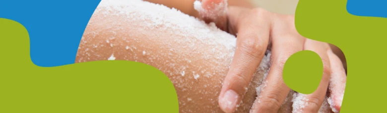 ruce aplikují třtinový cukr na kůži jako peeling