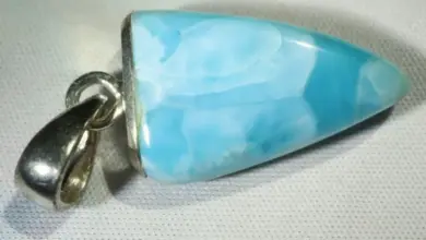Modrý kámen larimar v stříbrném náhrdelníku na bílém pozadí.