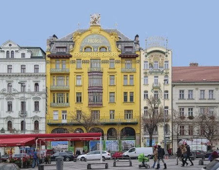 Řada historických budov v pražském náměstí s různými architektonickými styly.