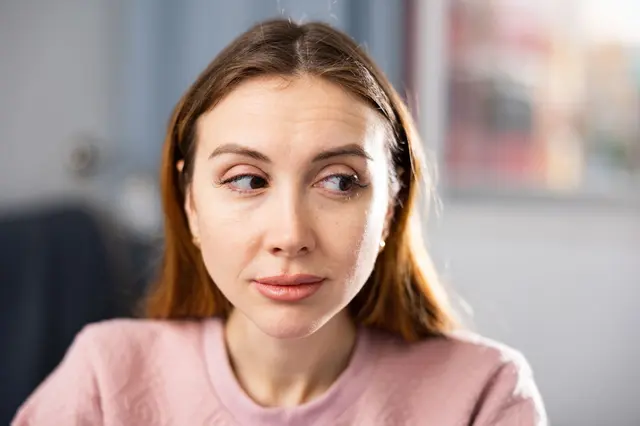 Žena se dívá stranou, ne do očí.