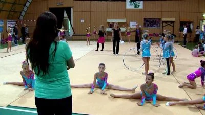 Děvčata se učí rytmické gymnastice pod dohledem trenéra.