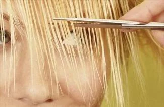 Stříhání vlasů nůžkami na blond vlasy.