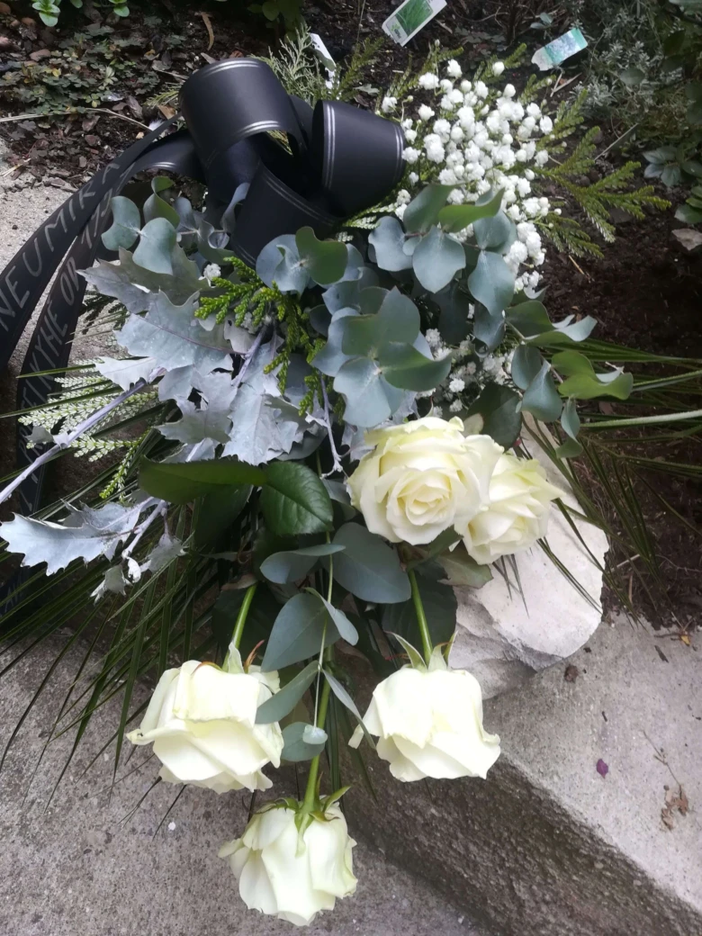 Bouquet bílých růží s černým stužkou na pohřeb.