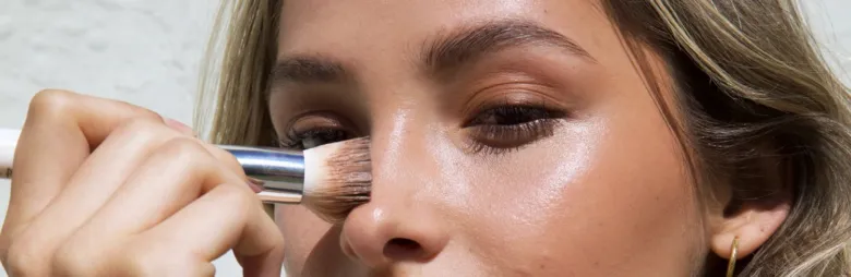 Žena aplikuje make-up na nos pro správné tónování pleti.