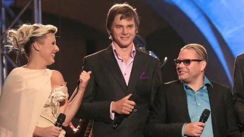 Three people on stage with microphones