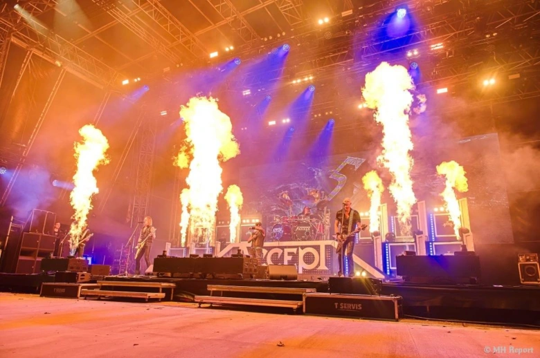 Rocková kapela vystupuje na scéně s ohňostrojem.