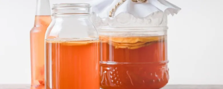 Sklenice s fermentující kombuchou připravené k pití nebo vyhození.