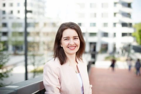 Žena v kancelářském prostředí na pozadí městské zástavby.