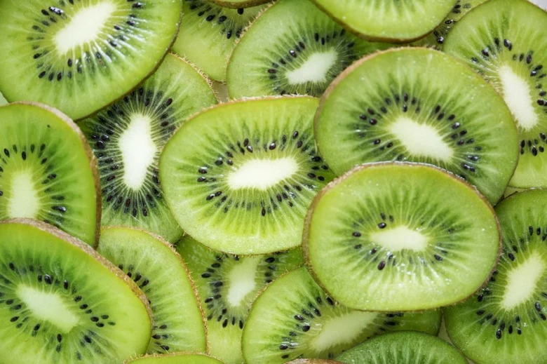 Svěží plátky kiwi s zelenou dužinou a černými semínky.