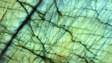 Detail zeleného drahokamu Labradorit s modrozeleným leskem.
