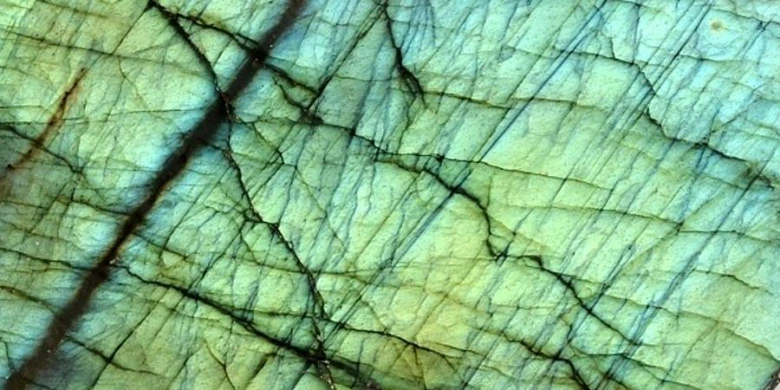 Detail zeleného drahokamu Labradorit s modrozeleným leskem.