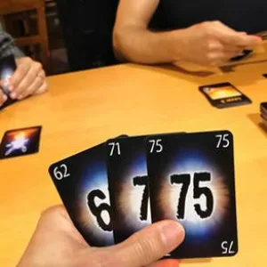 Ruka drží karty v herní hře pro trénink paměti.